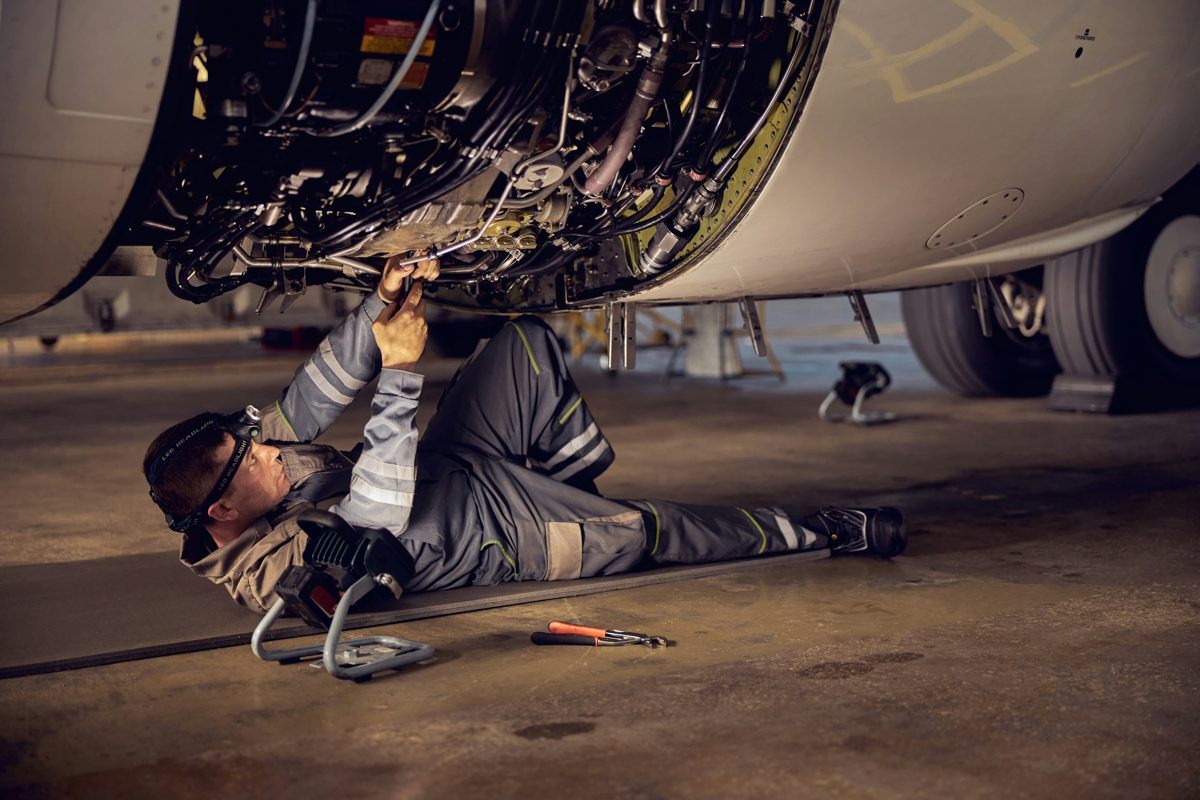 Technician working on aircraft engine accessories in the hangar