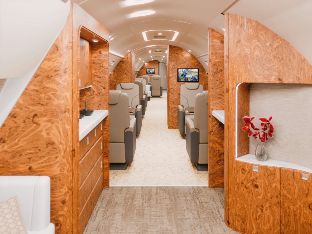 Corporate jet cabin interior with wood veneer and leather seating